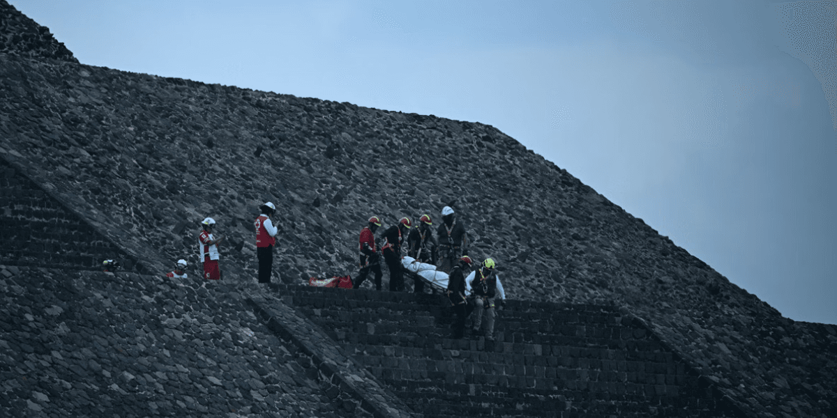 Peritos forenses e membros da Cruz Vermelha transportam um corpo na zona arqueológica de Teotihuacan, no México