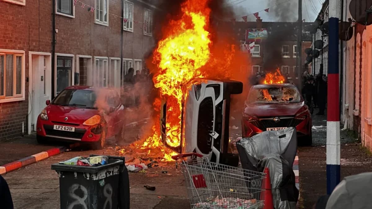 Veículos incendiados por manifestantes na Rua Lendrick, em Belfast